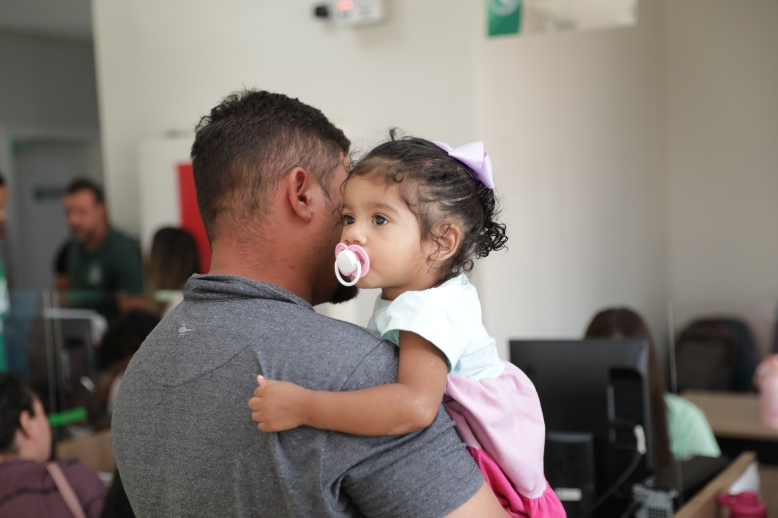 Pai aguarda atendimento com a filha durante ação do programa Meu Pai Tem Nome.